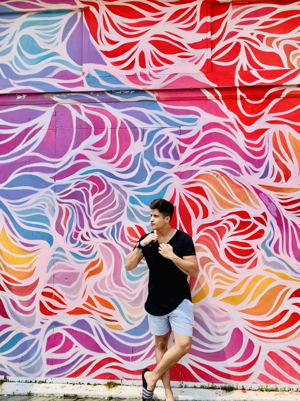 Vallber portrait in front of a colorful mural
